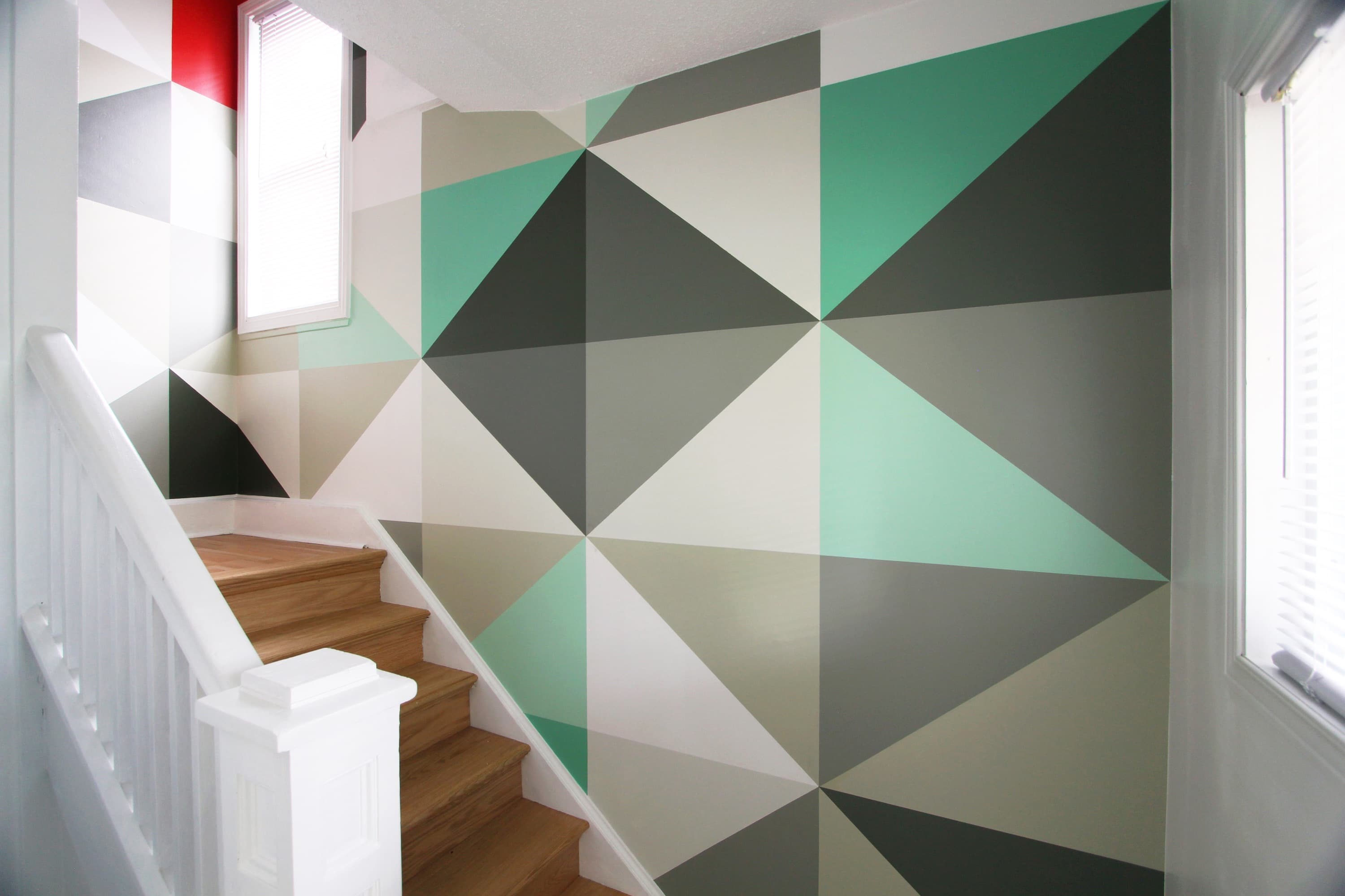 Mint & Vermillion — the stairwell wall after the triangulated mural was installed.